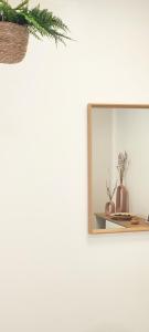 a mirror on a wall with a shelf and vases at Cozy Rooms Luna - Home Gym in Zadar