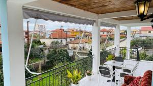 a patio with a table and chairs on a balcony at Mia Guest House - Entire home with balcony & garden in Divjakë