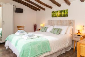 a bedroom with a large white bed and a tv at Casa rural "Cuenta la Leyenda..." in Bulbuente
