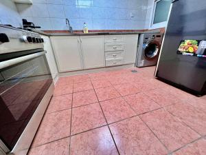 a kitchen with a pink tile floor and a dishwasher at Luxury Awaits: Master Bedroom for Rent! Indulge in comfort and style. in Sharjah