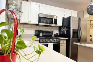 a kitchen with white cabinets and a stainless steel refrigerator at Green #23 in Northbrook