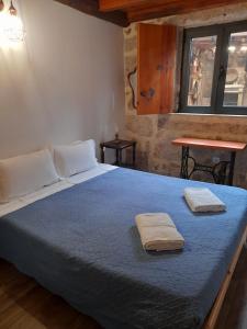 a bedroom with a bed with two towels on it at Casa do Garrano - Gerês in Vilar da Veiga