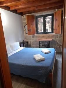 a bedroom with a bed with two towels on it at Casa do Garrano - Gerês in Vilar da Veiga