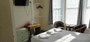 a room with a bed and two chairs and a window at 100 Pipers Hotel in Blackpool