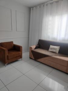 a living room with a couch and a chair at Aconchego in Campo Grande