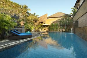a swimming pool in the middle of a house at Vamana Resort - CHSE Certified in Gili Trawangan