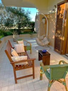 een patio met stoelen, een schommel en een hangmat bij Casa al mare con giardino in Alghero