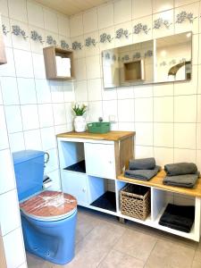 a bathroom with a blue toilet and a sink at Gästhaus "Seeblick" in Seekirchen am Wallersee
