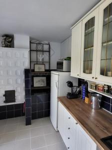uma cozinha com armários brancos e um frigorífico branco em Kuća za odmor na Mrežnici em Duga Resa