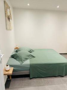 Un dormitorio con una cama con sábanas verdes y una mesa. en Villa Mahé, Majestueuse villa avec piscine, F4 à Ducos en Ducos