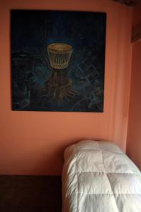 a painting hangs above a bed in a room at Alojamiento + Casa de Arte en Mendoza(ARG) in Guaymallen