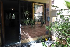 a brick house with a window and plants on it at Alojamiento + Casa de Arte en Mendoza(ARG) in Guaymallen