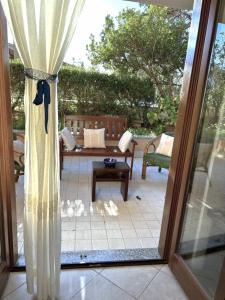 een glazen schuifdeur naar een patio met een tafel bij Casa al mare con giardino in Alghero