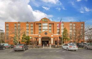 Extended Stay America Premier Suites - Cleveland - Independence في إنديبندنس: مبنى كبير من الطوب مع سيارات تقف في موقف للسيارات