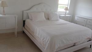 Wheeland SettlementNew condo with sea view (unit 3 of 3)的卧室内的白色床、白色床单和枕头