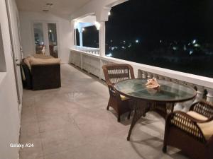Wheeland SettlementNew condo with sea view (unit 3 of 3)的阳台配有桌椅和窗户。 更多2张照片