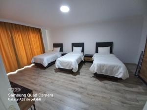 um quarto com duas camas com lençóis brancos em pointrezidans em Ancara