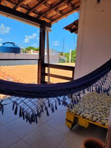 a hammock on a boat with a view of the beach at Casa Meu Cantinho in Barra de São Miguel