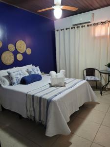 1 dormitorio con 1 cama grande y pared azul en Casa Meu Cantinho, en Barra de São Miguel