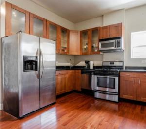 a kitchen with stainless steel appliances and wooden cabinets at Modern Belden in Chicago