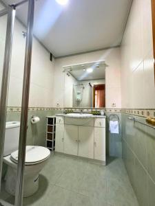 a white bathroom with a toilet and a sink at Apartamento Acogedor al lado del Estadio Bernabéu in Madrid