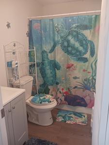a bathroom with a turtle shower curtain and a toilet at Turtles Nest of Port Orange in Port Orange