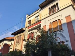 un edificio con un albero di fronte di Ambra Boutique Hotel a Milano