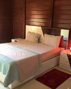 Schlafzimmer mit einem großen Bett mit einem Kopfteil aus Holz in der Unterkunft Resort Nabruni in Belas