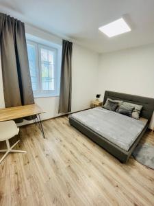 sypialnia z łóżkiem i drewnianą podłogą w obiekcie Apartment Riviéra Centrum, private parking and smart check in w Bańskiej Bystrzycy