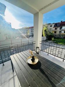 a wooden table with a vase on top of a balcony at Apartment Riviéra Centrum, private parking and smart check in in Banská Bystrica
