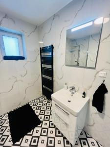 ein Badezimmer mit einem weißen Waschbecken und einem Spiegel in der Unterkunft Apartment Riviéra Centrum, private parking and smart check in in Banská Bystrica