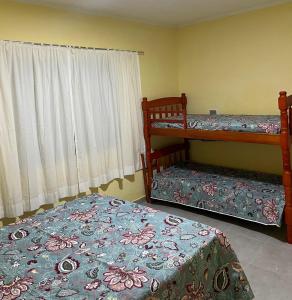 a bedroom with two bunk beds and a window at Apto. em Conceição dos Ouros MG in Conceição dos Ouros