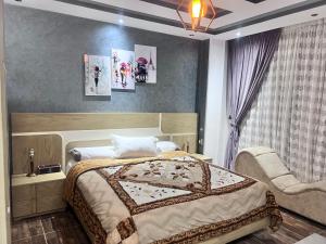 a bedroom with a bed and a chair at Villa Contenental residense El sheikh Zayed Beverly Hills in Sheikh Zayed