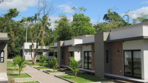 a building with trees in the background at Vila do Porto Pousada in Morretes