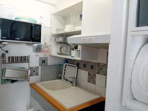 a kitchen with a sink and a microwave at Résidence au soleil avec Piscine à 150m de la plage - Barcarès in Le Barcarès