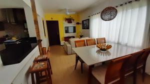 a dining room and living room with a table and chairs at Rota 12- Hospedagem memorável no Guarujá in Guarujá