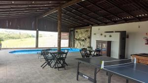 una stanza con due tavoli da ping pong e sedie di Hotel Fazenda Estancia do Lago a Guapirama