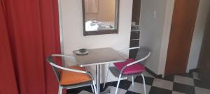 lugar tranquilo في فيسنتي لوبيز: طاولة صغيرة و كرسيين في الغرفة