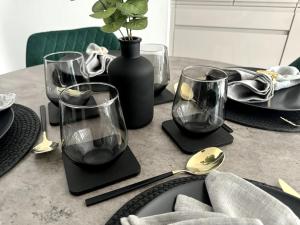 a table with four wine glasses and a vase at Luxury Oaks Suite, Free private parking, 2 Bed 2 Bathroom Apartment, Central Solihull in Birmingham