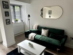 a living room with a green couch and a table at Luxury Oaks Suite, Free private parking, 2 Bed 2 Bathroom Apartment, Central location in Birmingham