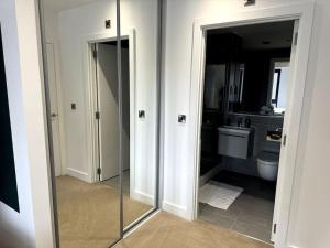 a bathroom with a toilet and a glass door at Luxury Oaks Suite, Free private parking, 2 Bed 2 Bathroom Apartment, Central location in Birmingham