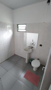 Baño blanco con lavabo y aseo en Hostel do Cerrado, en Cavalcante