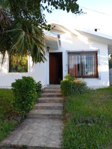 ein weißes Haus mit einer Treppe, die zu einer Tür führt in der Unterkunft La casa in Santana do Livramento