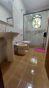 a bathroom with a sink and a toilet and a window at La casa in Santana do Livramento