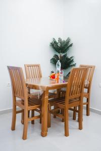 a wooden table with three chairs and a christmas tree at Appartement Chic et Luxueux Corniche Tanger in Tangier