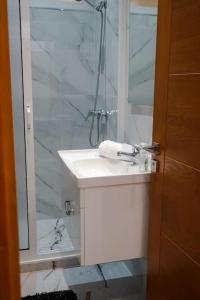 a bathroom with a white sink and a shower at Appartement Chic et Luxueux Corniche Tanger in Tangier