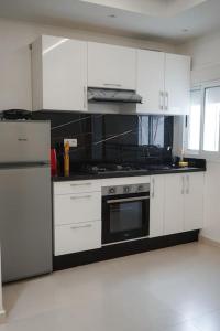a kitchen with white cabinets and a stove top oven at Appartement Chic et Luxueux Corniche Tanger in Tangier