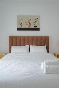 a bed with white sheets and two towels on it at Appartement Chic et Luxueux Corniche Tanger in Tangier