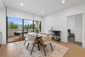 a dining room with a table and chairs at Luxury Waterfront 2 Bed near Olympic Park & Parra in Sydney