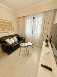 uma sala de estar com um sofá preto e uma mesa em Sao Paulo Ibirapuera Privilege - Suite Deluxe em São Paulo